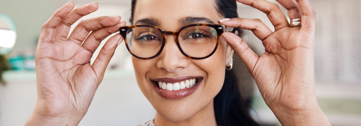 Jeune femme essayant une paire de lunettes de vue